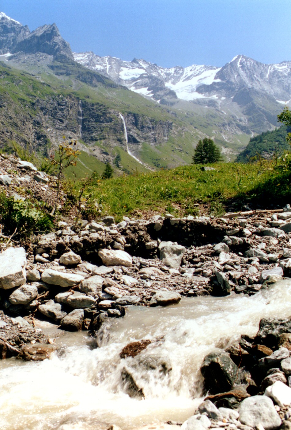 Torrent de montagne avec deux cascades dans le lointain