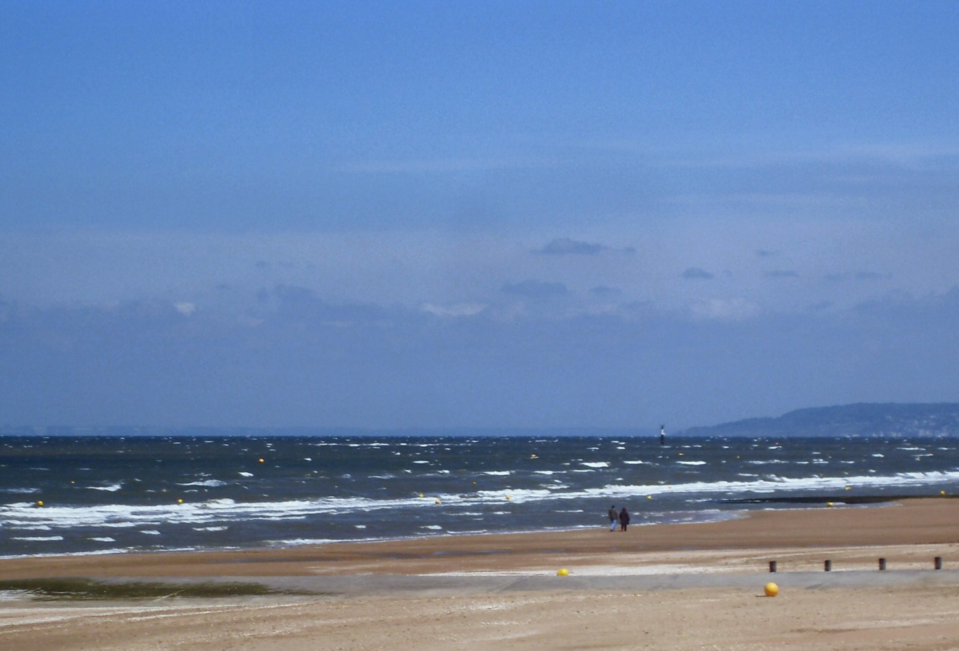 La plage de Cabourg et deux promeneurs
